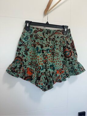 Ulla Johnson high-waist green patterned shorts with orange, black, and turquoise